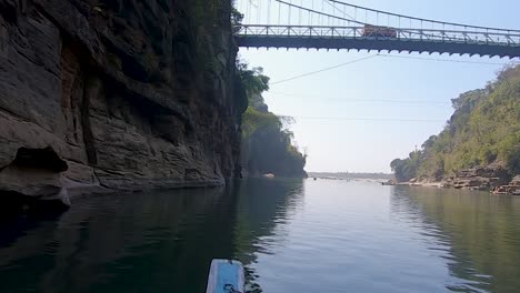 Paisaje-Fluvial-Con-Puente-Desde-Un-Barco-De-Madera-Tradicional-Con-Montaña-Y-Cielo-Brillante-En-El-Día-Se-Toma-Un-Video-En-El-Río-Umtong-Dawki-Meghalaya-Al-Noreste-De-La-India