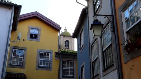 Bunte-Gebäudewände-Umrahmen-Den-Glockenturm-Der-Kirche-San-Lorenzo-Dos-Riglos-In-Largo-Da-Pena-Ventosa,-Porto,-Portugal