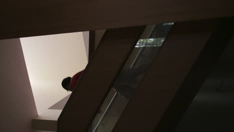 man walks up the wooden staircase alone in a house, vertical video sequence shot