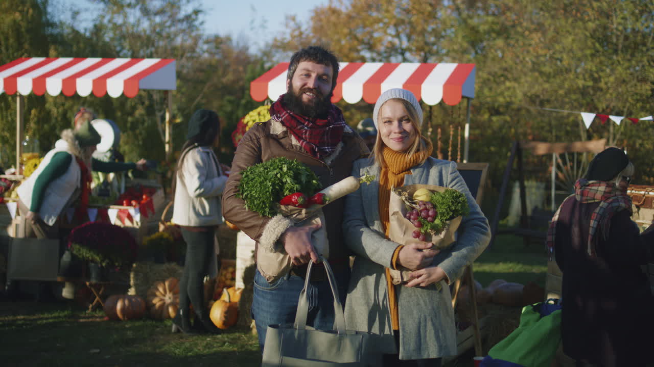 Spouses Posing with Bag of Fruits Spouses Posing with Bag of Fruits or Vegetables and Looking at Camera Smilling and Feeling Happy after Shoping on Farmers Market