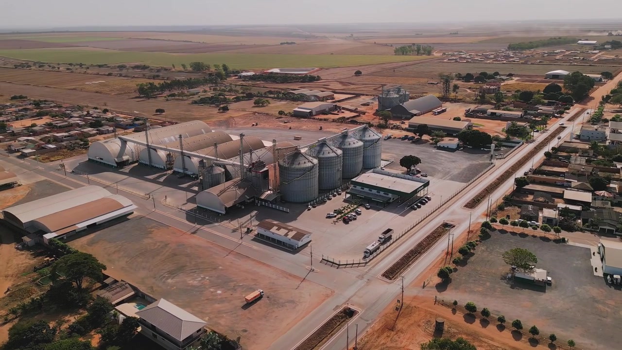 Aerial view of a large grain elevator and silo facility in a rural town. Industrial agribusiness complex for crop storage and processing