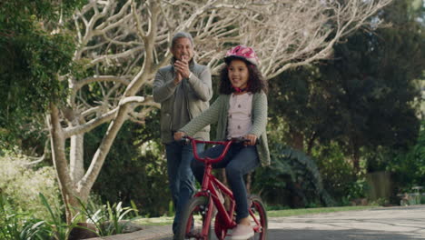 Grandfather-teaching-child-to-cycle-on-her-first