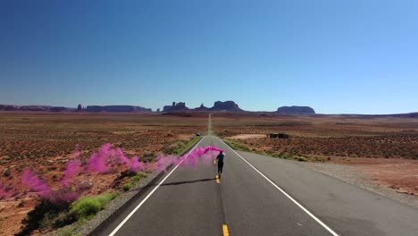 hombre corriendo en la carretera en utah con señal de humo de color