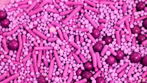 macro view of pink candy sprinkles cascading onto a surface, creating a dynamic, colorful pattern