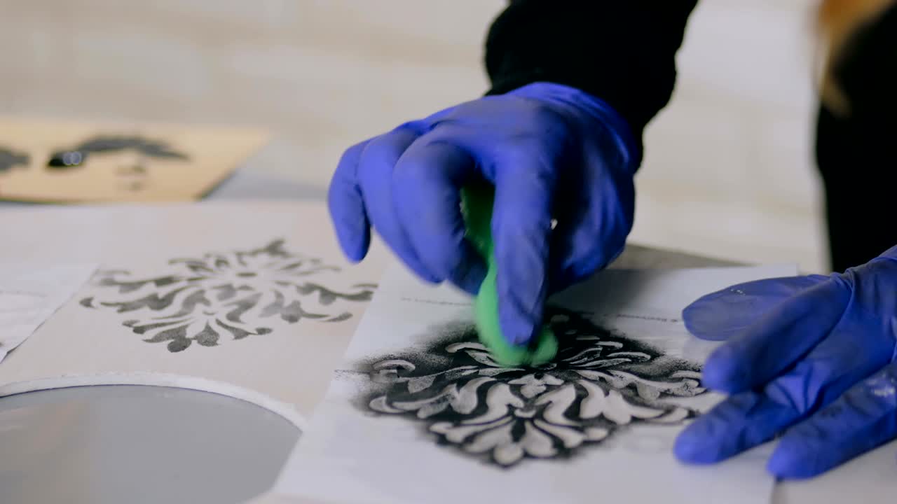 manos de mujer pintando círculo de madera