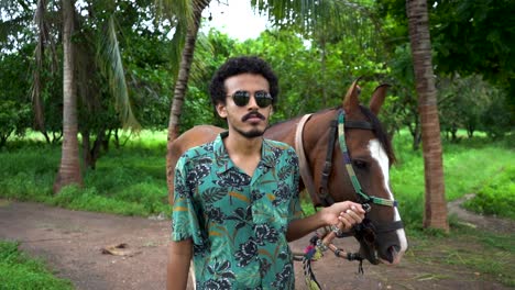 young handsome man with brown horse