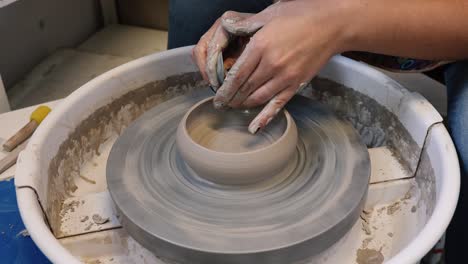 young woman in pottery studio using pottery wheel, handmade ceramics, creative