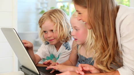 mother using a laptop with her children