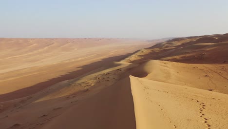 un hombre saltando sobre inmensas dunas de arena del desierto