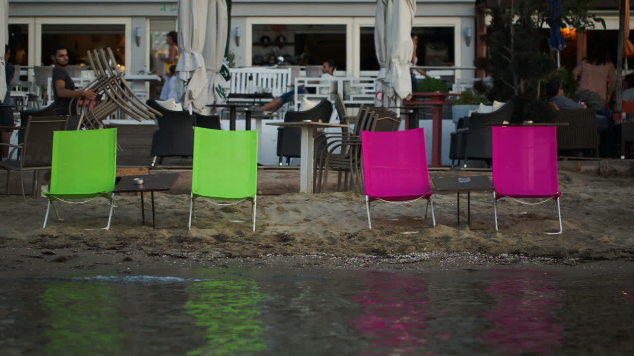 sillones vacíos en la playa y cafetería al aire libre