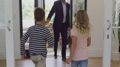 father embracing his two children as he enters the house 4k