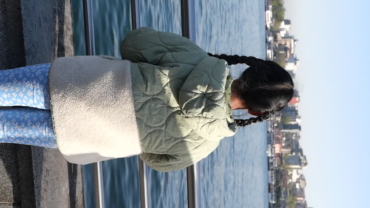 A woman with braids standing near a body of water
