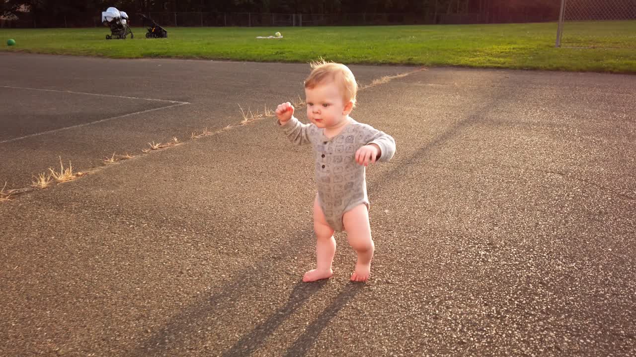 un niño feliz da sus primeros pasos sin ayuda en un patio escolar vacío