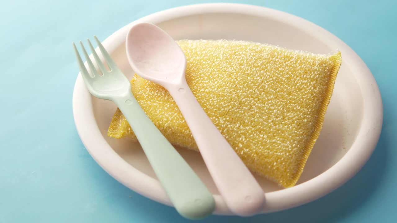 Utensilios de plástico y esponja en un plato