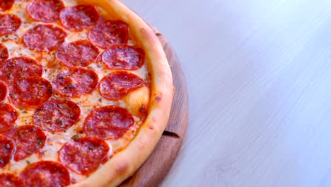 pizza de salami en una tabla de madera en la mesa.
