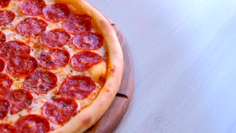 salami pizza on wooden board on the table.