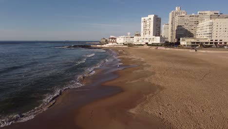 Eine-Drohne-überfliegt-Einen-Touristen-An-Einem-Sandstrand-In-Uruguay