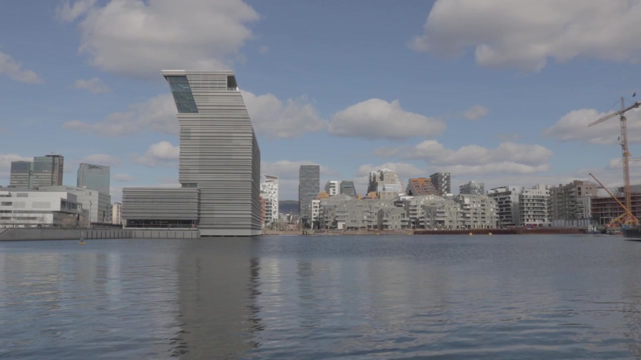 Horizonte moderno del distrito Barcode reflejado en el puerto de Oslo en un día soleado
