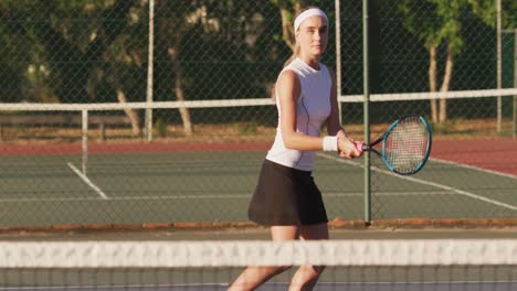 Video-of-focused-caucasian-female-tennis-player-holding-racket-and-hitting-ball