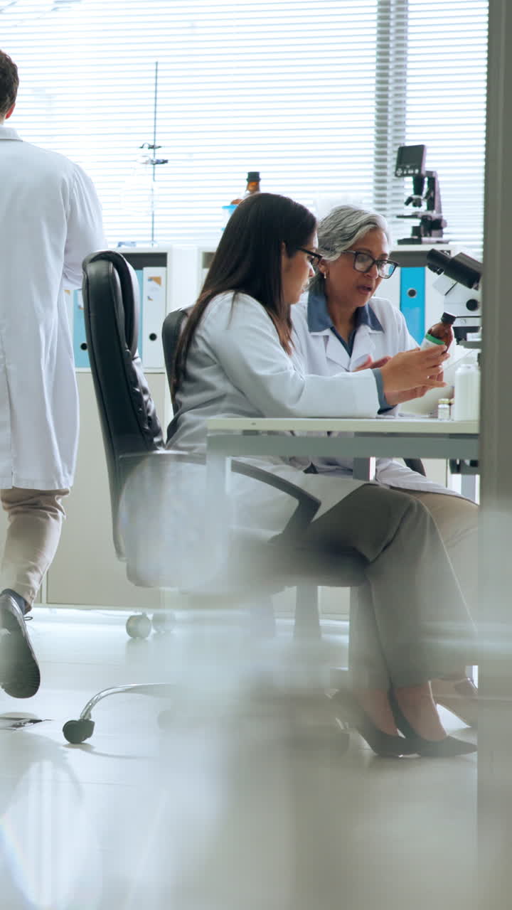 Dos científicas discutiendo investigación en un laboratorio moderno