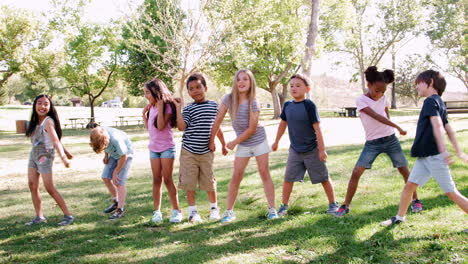 Grupo-De-Niños-Con-Amigos-En-El-Parque-Bailando-Y-Usando-Hilo-Dental