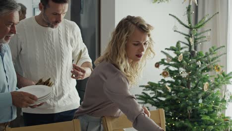 un hombre mayor con una hija adulta preparando la mesa para la víspera de navidad.