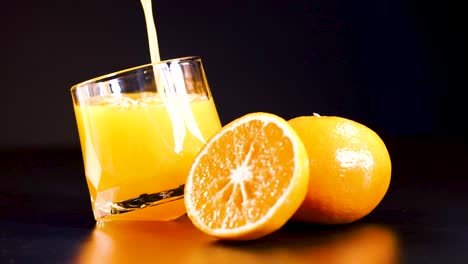 juice pouring into glass with oranges nearby