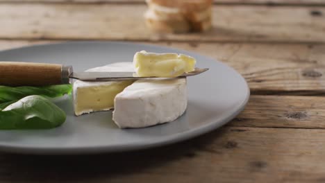 Video-of-knife-and-soft-cheese-on-plate-and-rustic-wooden-table-with-copy-space