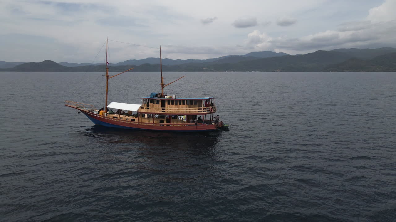 vista aérea del barco de madera con turistas navegando en la costa de bali, indonesia