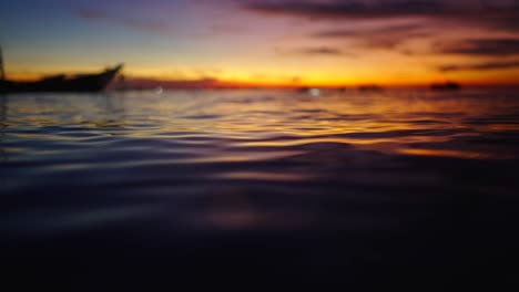 golden sunset over calm water with distant boats