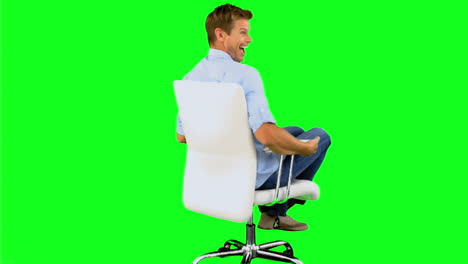 smiling man turning on swivel chair on green screen