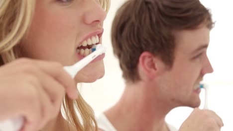 couple wash their teeth with electronic toothbrush