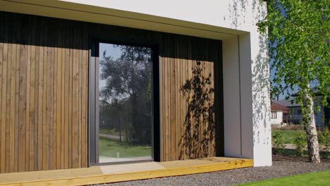 modern house exterior with wooden siding and glass door