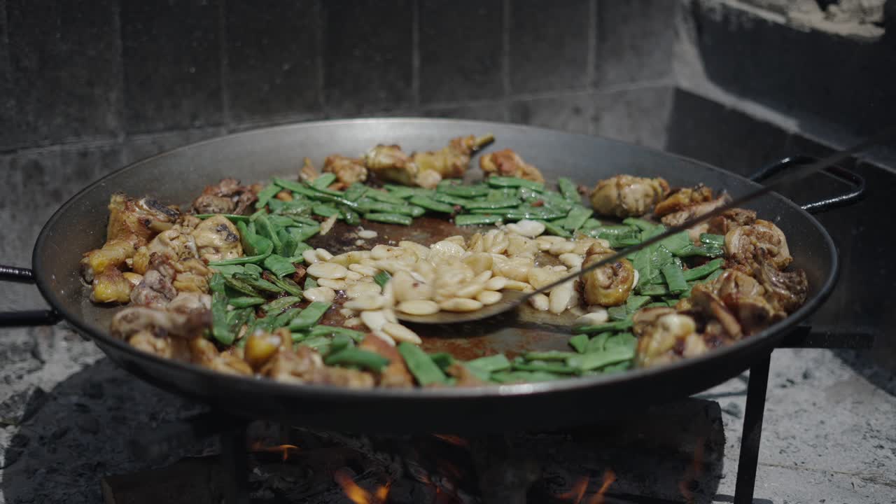 Preparazione di paella tradizionale su fuoco aperto