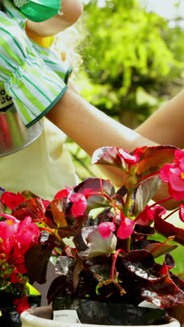 cute girl watering flowers with her mother