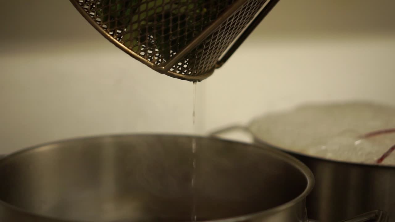 SLOWMO - Close Up - Draining steamed green fresh broccoli and putting it on a plate