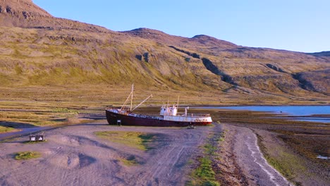 aerial over abandoned fishing boat sitting on the shore of the westfjords iceland 3