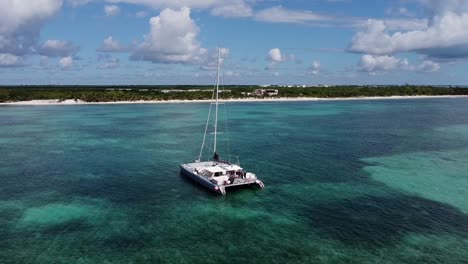 drone zoom-out shot of a catamaran on the caribbean sea at midday