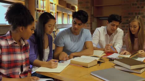 classmates studying in library smiling at camera