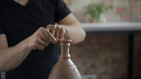 pottery artist shaping a clay vessel