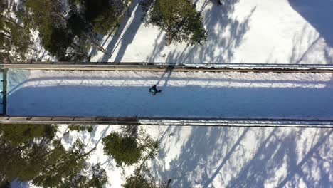 Man-walking-towards-edge-of-Stegastein-viewpoint-seen-from-birdseye-perspective---Cool-top-down-view-of-person-reaching-tip-of-attraction-with-beautiful-leading-lines