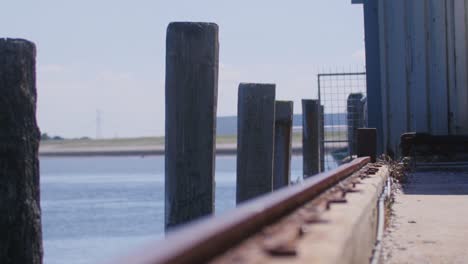 Increíble-Toma-De-Un-Muelle-En-La-Playa-Con-Un-Pájaro-Volando-En-El-Fondo-En-Cámara-Lenta