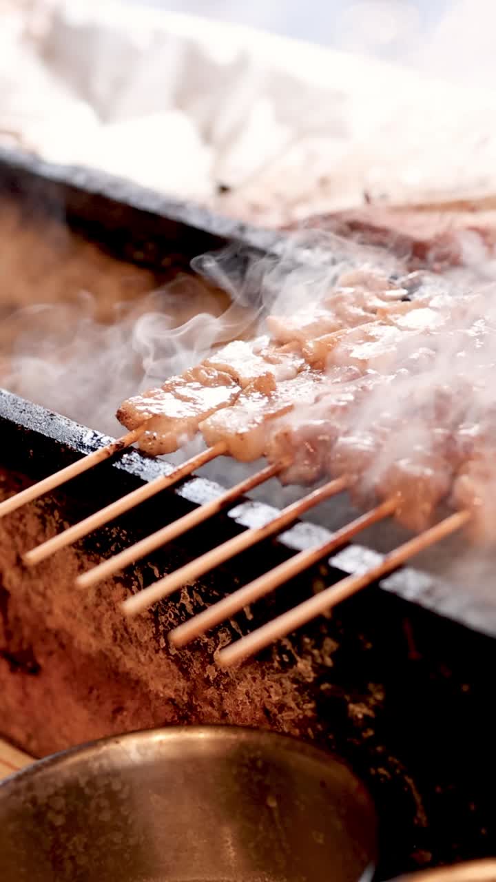 연기가 난 그릴 위에 인 고기를 손으로 돌리는 것