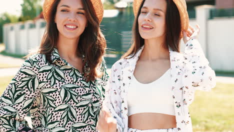 two women wearing straw hats