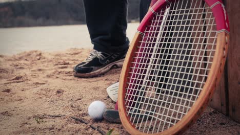 Golf-ball-and-club-set-down-next-two-other-sporting-equipment-on-beach