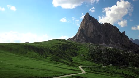 antenna su una piccola strada di campagna, passo di giau verso una grande montagna nelle alpi, dolomite, italia