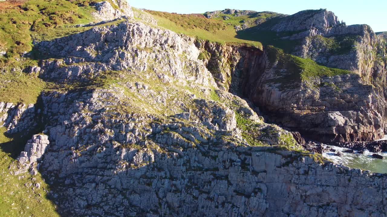 Aerial Reveal of Collapsing and Eroding British Coastline with Small Beach Cove Below. Travel Nature Drone Clip. Beautiful Welsh Gower Peninsula Coast
