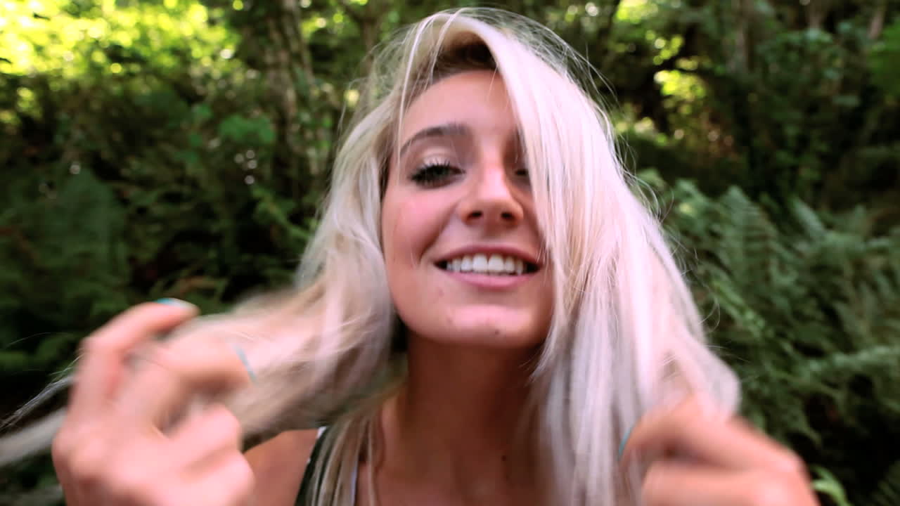 una rubia atractiva jugando con su cabello.