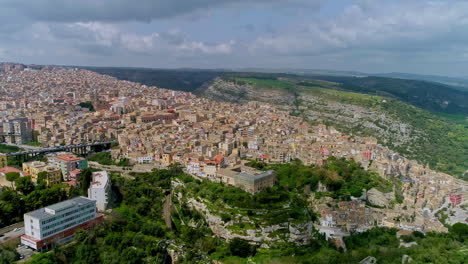 aerial forwarding shot of residential buildings and houses in the old historic town of ragusa ibla in sicily, italy on a bright sunny day