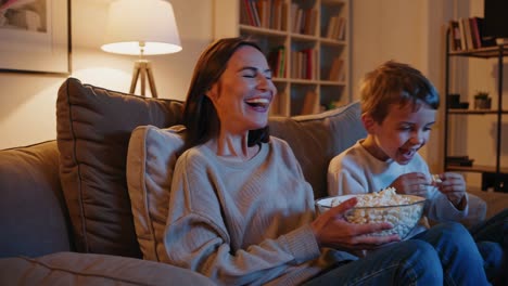 mother and son enjoying movie night with popcorn